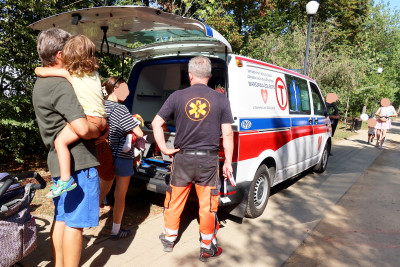 Grupa ludzi z dziećmi zwiedzają ambulans medyczny